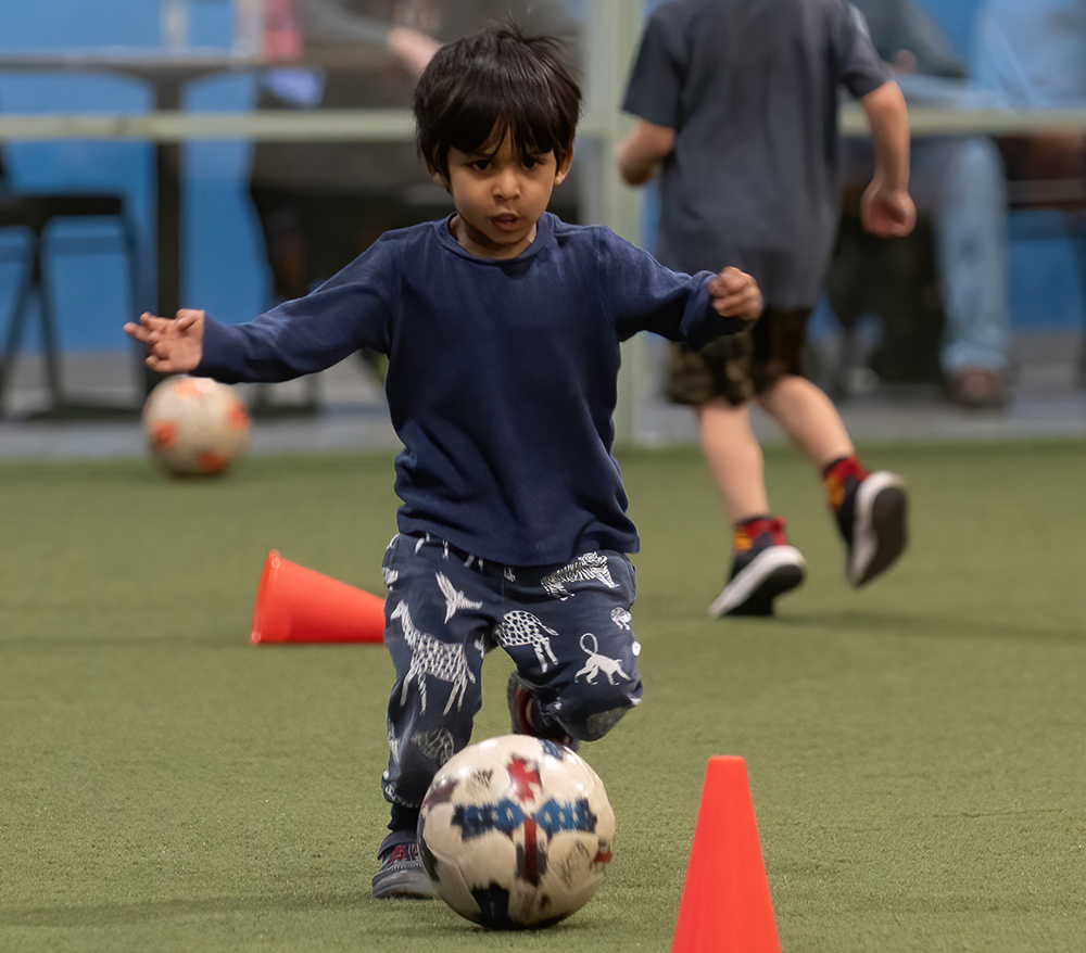Little boy works on his dribble skills at Locker Soccer Academy