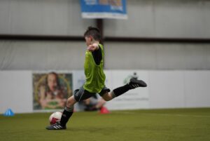 School of Excellence, boy in yellow pinny, free kick