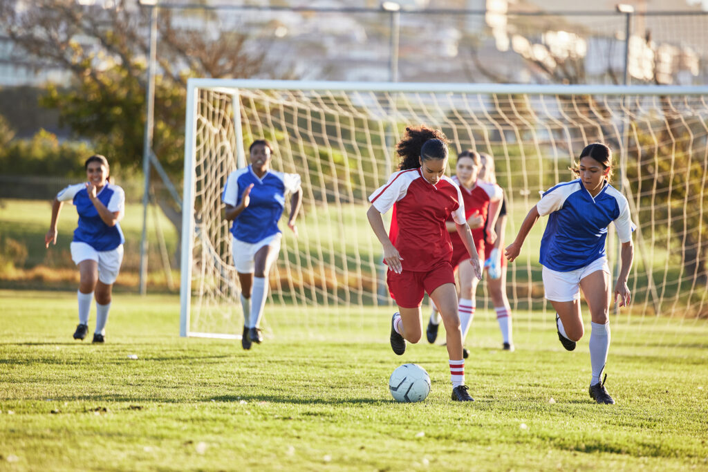 Youth girls soccer players during a match, chasing the ball - Locker Soccer Academy