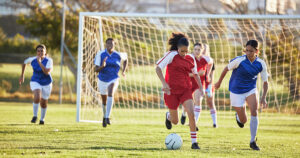 Youth girls soccer players during a match, chasing the ball - Locker Soccer Academy