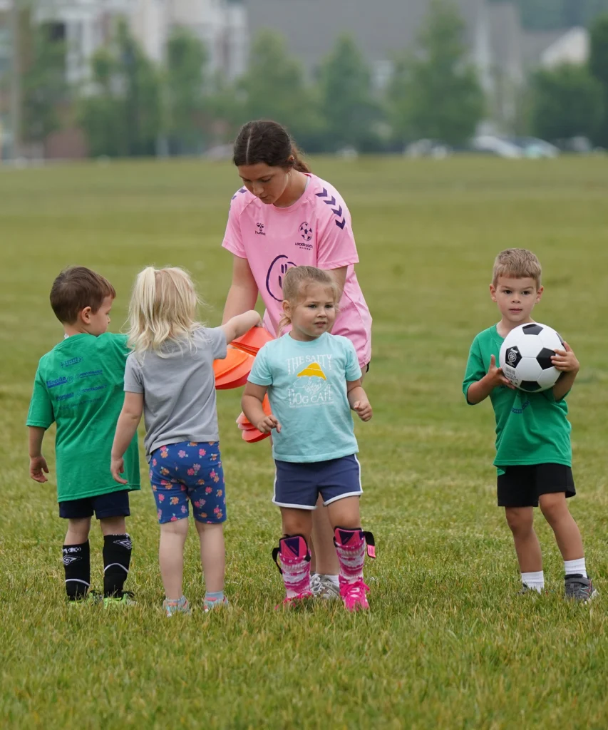 Locker Soccer Academy coach helps preschool players hand out cones while setting up a fun soccer drill