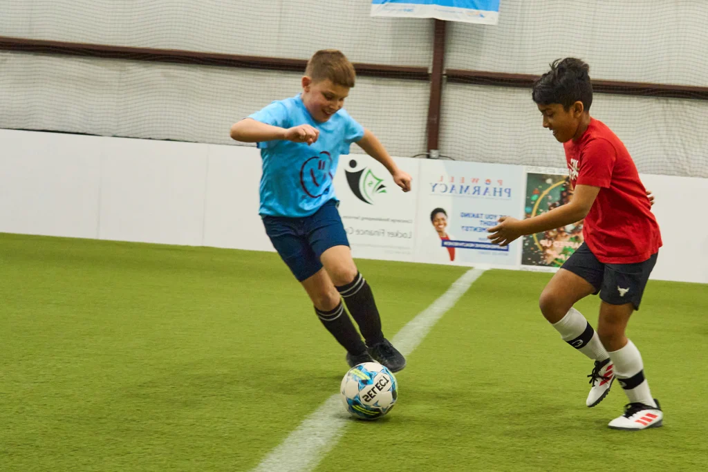 Youth soccer player dribbling past defender during 1v1 drill